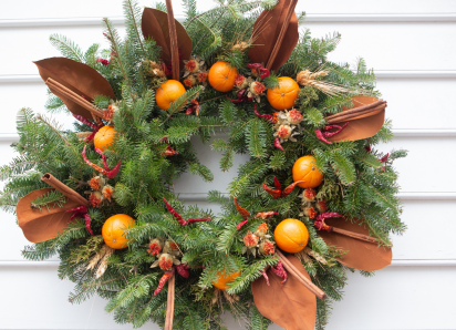 Green circle wreath with oranges and orange leafs around it